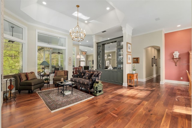 living area featuring visible vents, arched walkways, crown molding, baseboards, and dark wood-style flooring