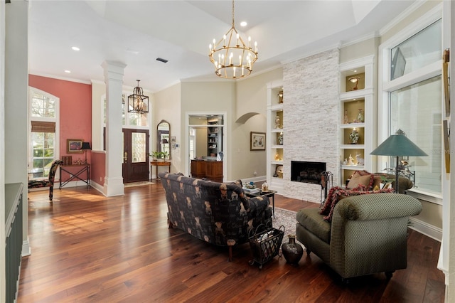 living room featuring a notable chandelier, crown molding, visible vents, and hardwood / wood-style flooring