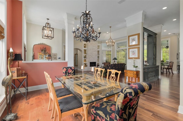 dining space with wood finished floors, baseboards, recessed lighting, crown molding, and a notable chandelier