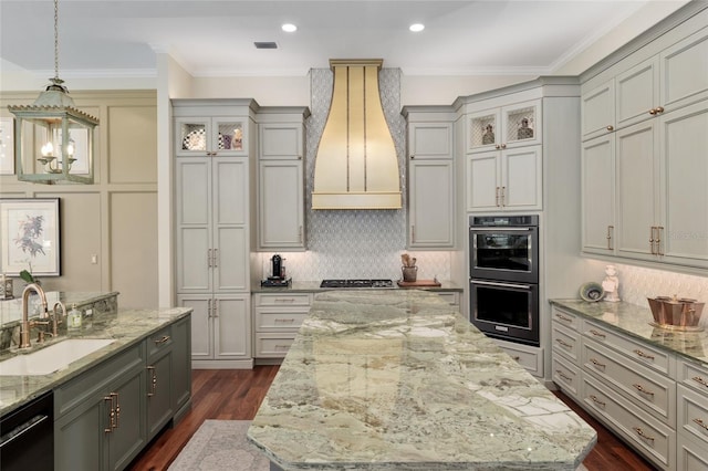 kitchen with dark wood finished floors, custom exhaust hood, a sink, dishwasher, and double oven