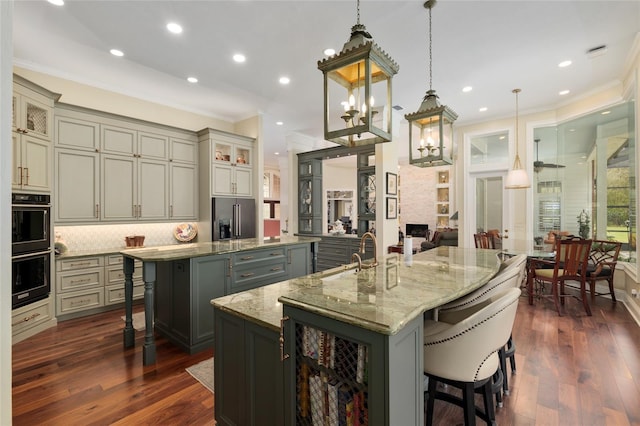 kitchen with a large island, high end fridge, gray cabinets, a kitchen breakfast bar, and wine cooler