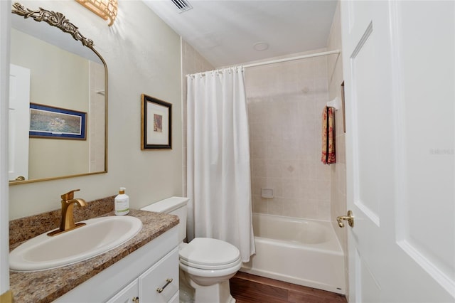 bathroom featuring shower / bath combination with curtain, toilet, vanity, and wood finished floors