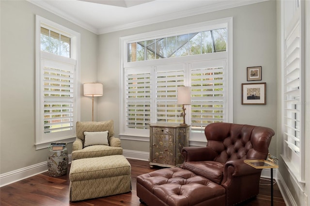 sitting room featuring dark wood-type flooring, crown molding, and a healthy amount of sunlight