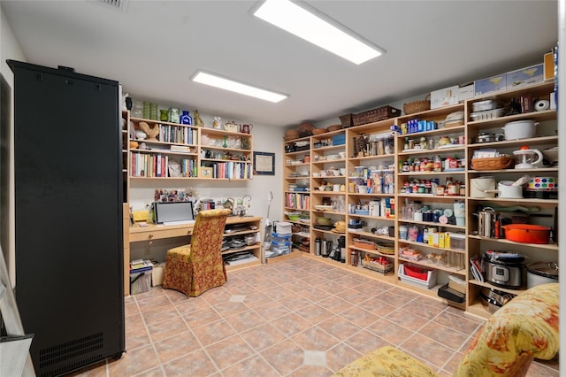 office with light tile patterned floors and built in study area