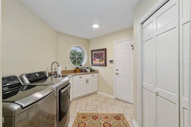 clothes washing area featuring a sink, baseboards, cabinet space, and independent washer and dryer