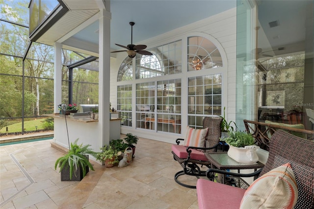 sunroom / solarium with visible vents and ceiling fan