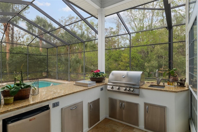 view of patio featuring a lanai, area for grilling, and an outdoor kitchen