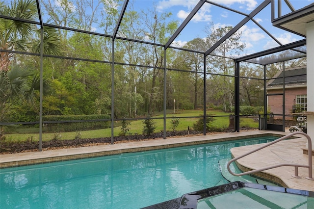 view of pool with glass enclosure, a pool with connected hot tub, and a patio area