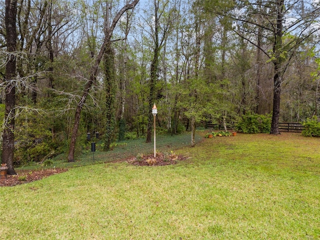 view of yard with a view of trees and fence