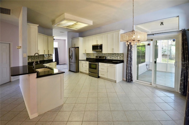 kitchen with dark countertops, visible vents, stainless steel appliances, and a sink