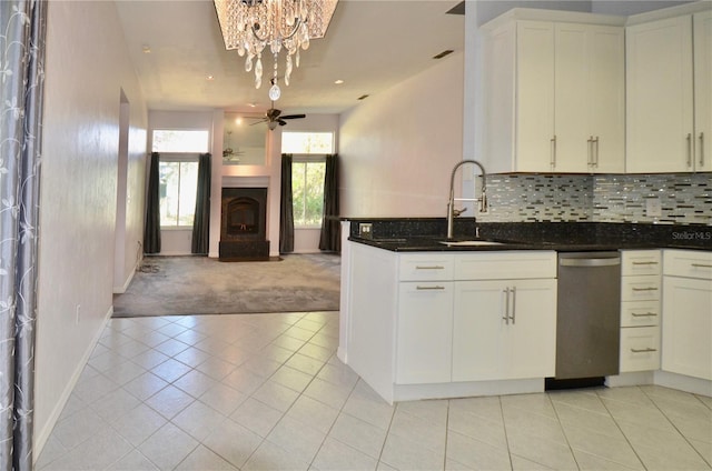 kitchen featuring ceiling fan, open floor plan, dishwasher, white cabinetry, and a sink