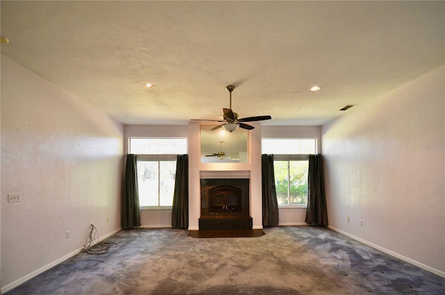 unfurnished living room featuring visible vents, baseboards, carpet, and a glass covered fireplace