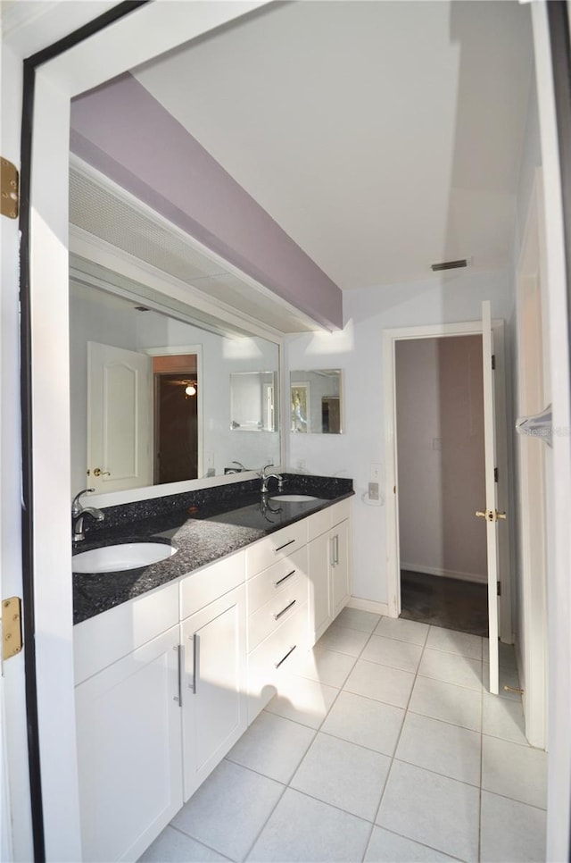 full bath featuring tile patterned flooring, double vanity, beam ceiling, and a sink