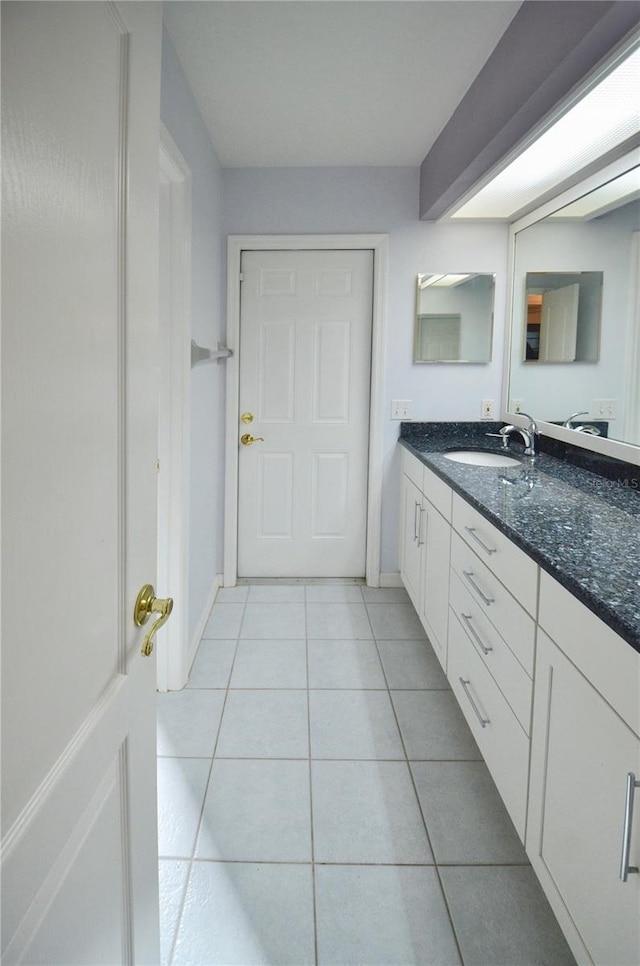 bathroom with tile patterned floors, baseboards, and vanity