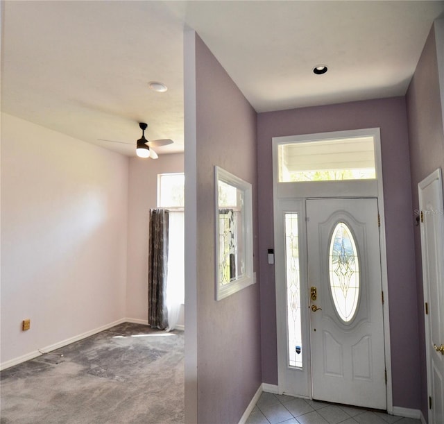 entryway with light colored carpet, baseboards, and ceiling fan