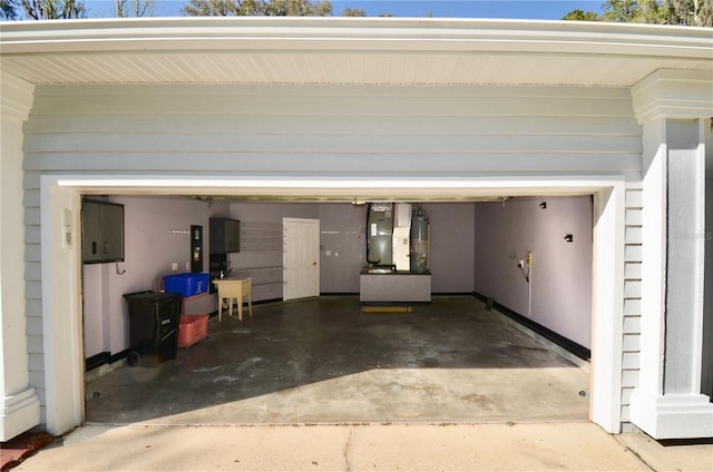 garage featuring heating unit, gas water heater, and concrete driveway