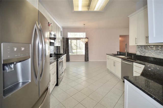 kitchen with light tile patterned floors, tasteful backsplash, appliances with stainless steel finishes, and a sink