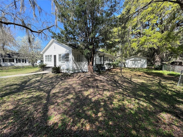 view of front of house with entry steps, fence, a shed, an outdoor structure, and a front lawn