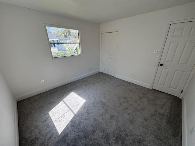 unfurnished bedroom with carpet floors, a closet, and baseboards