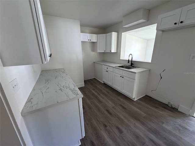 kitchen featuring dark wood-style floors, light countertops, white cabinets, and a sink