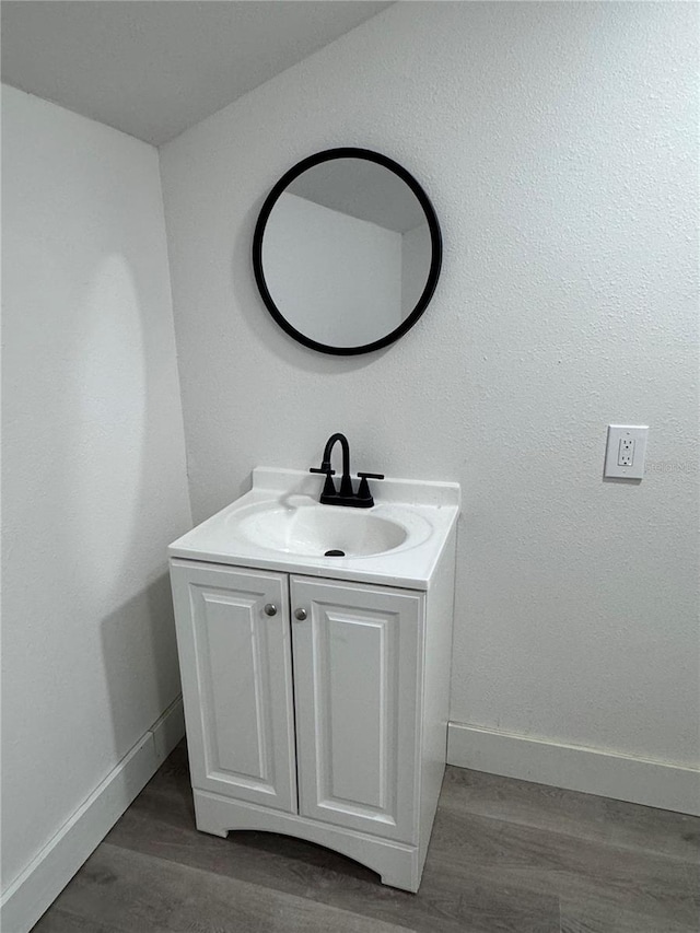 bathroom featuring wood finished floors, vanity, and baseboards