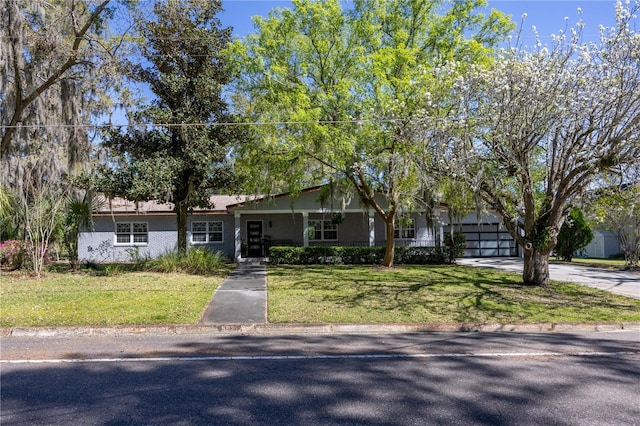 view of front of property featuring a front lawn, a porch, a garage, and driveway