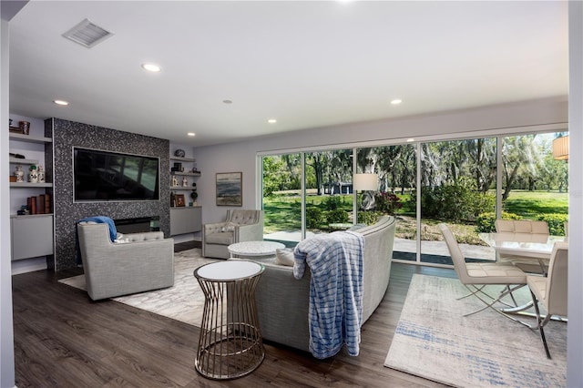 living area featuring a healthy amount of sunlight, visible vents, and dark wood-style flooring