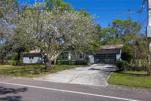 view of front of property with a front yard, an attached garage, and driveway