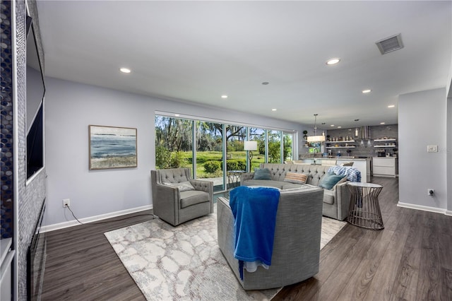 living room with visible vents, recessed lighting, dark wood-type flooring, and baseboards