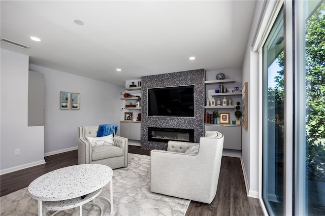 living room featuring recessed lighting, visible vents, wood finished floors, and a tiled fireplace