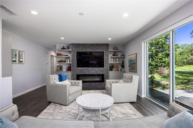 living room featuring recessed lighting, baseboards, wood finished floors, and a tile fireplace