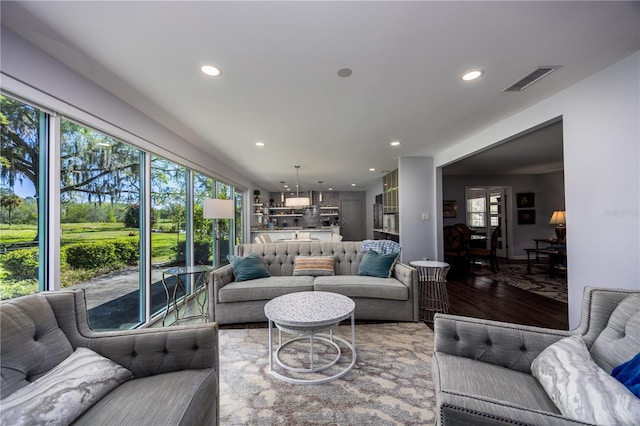 living room featuring an inviting chandelier, wood finished floors, recessed lighting, and visible vents