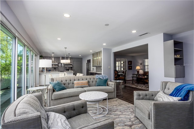 living room with recessed lighting, visible vents, and light wood finished floors