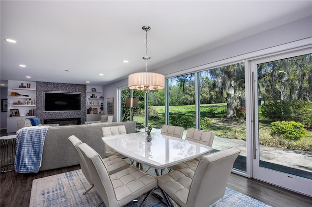 dining area with recessed lighting, a fireplace, and wood finished floors