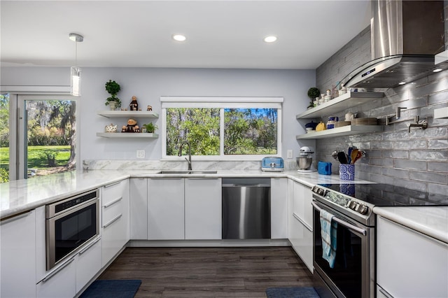 kitchen featuring open shelves, stainless steel appliances, white cabinetry, wall chimney range hood, and modern cabinets