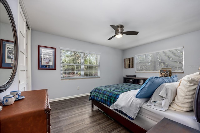 bedroom with a ceiling fan, dark wood-style floors, and baseboards