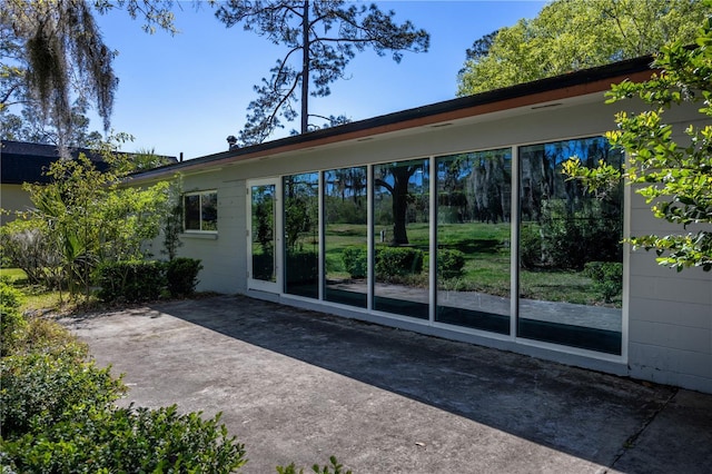 rear view of property with a patio area and concrete block siding