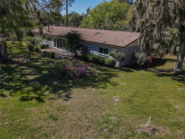 back of house with a yard and stucco siding