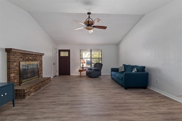 living room with a ceiling fan, a brick fireplace, baseboards, and wood finished floors