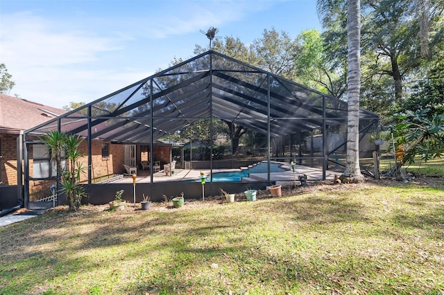 rear view of property with a lanai, brick siding, and a yard