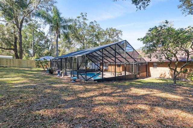 exterior space featuring a lanai, fence, a fenced in pool, and a yard