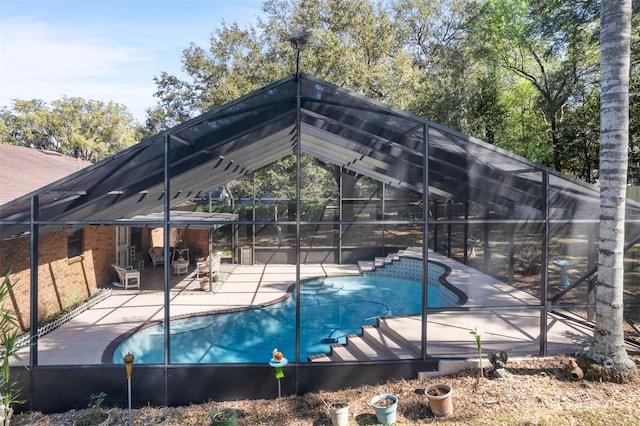 outdoor pool featuring glass enclosure and a patio