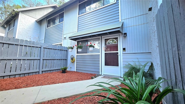 view of exterior entry featuring fence