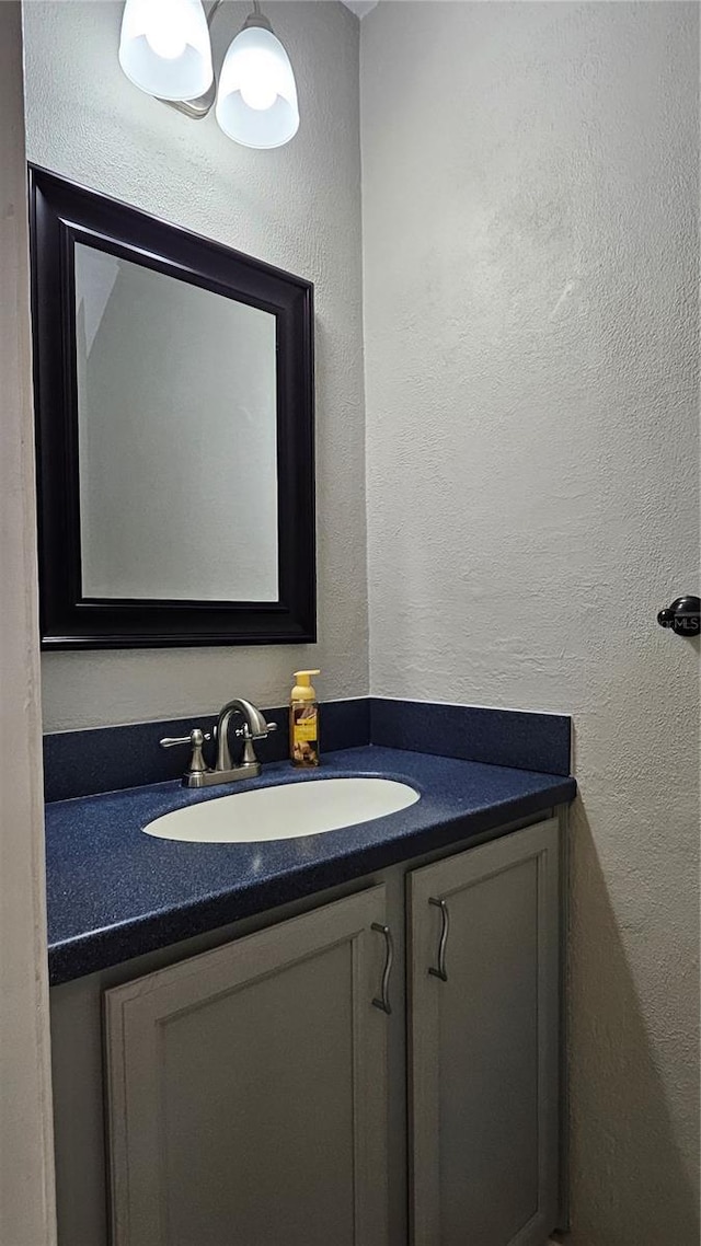 bathroom with a textured wall and vanity