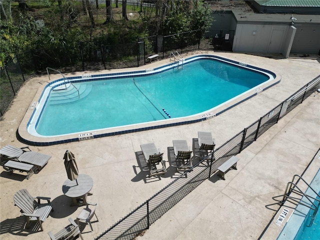 community pool featuring a patio and fence