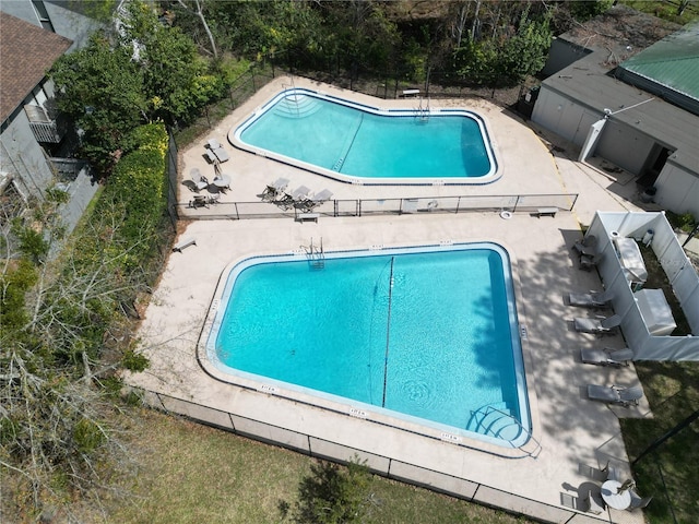 community pool featuring a patio and fence