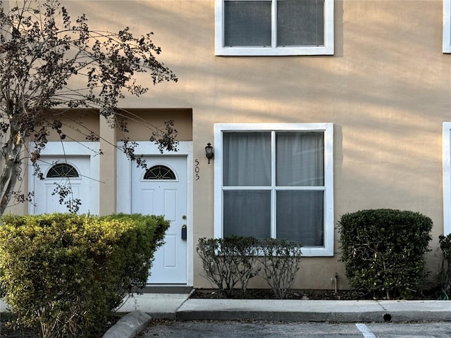 entrance to property featuring visible vents and stucco siding