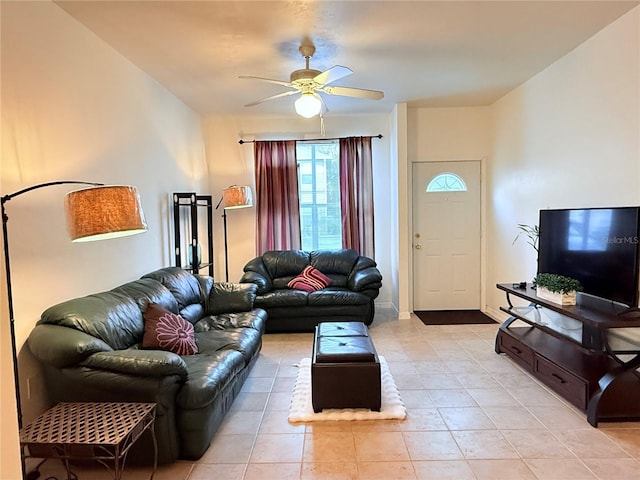 living area with baseboards, a ceiling fan, and light tile patterned flooring