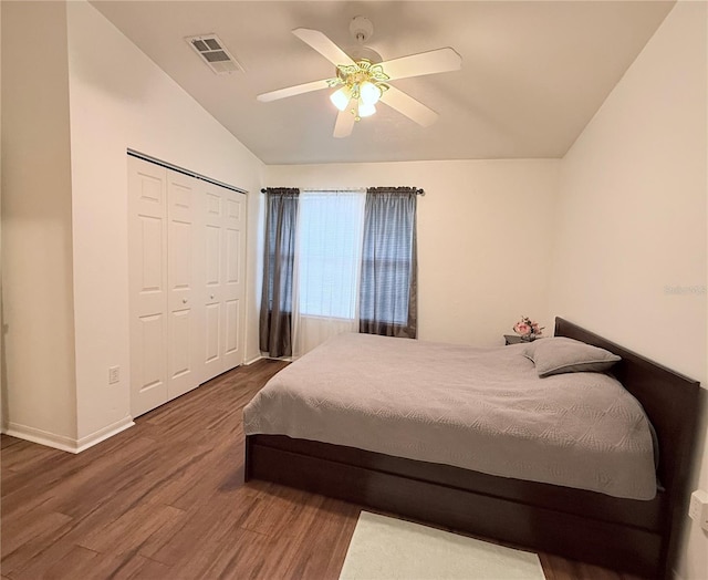 bedroom featuring visible vents, ceiling fan, wood finished floors, vaulted ceiling, and a closet