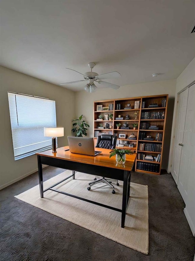 carpeted office featuring ceiling fan and baseboards